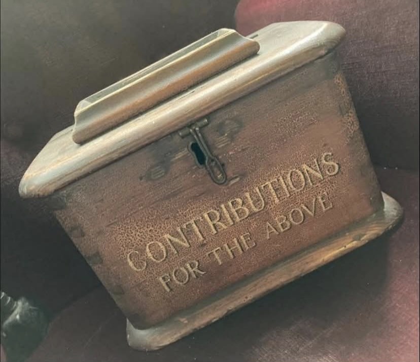 An antique wooden collection box carved with the words Contributions For The Above